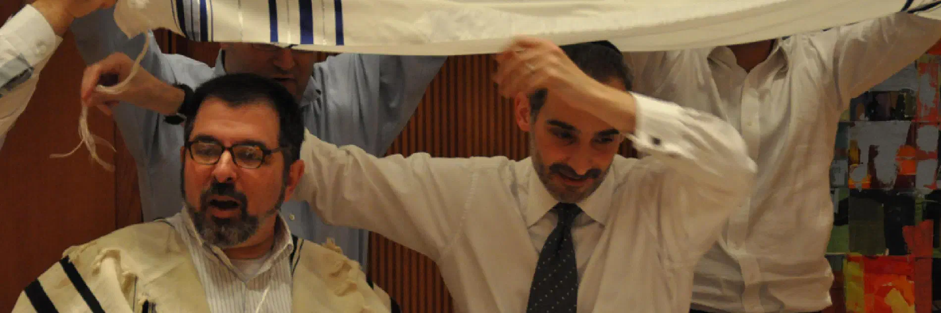A tallit held overhead as a canopy during a celebration